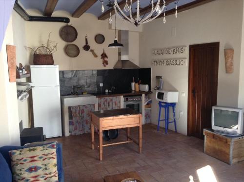 Casa Rural Pico Espadan في Almedíjar: مطبخ مع ثلاجة وطاولة في الغرفة