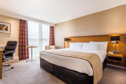 a hotel room with a large bed and a desk at Holiday Inn Newcastle Gosforth Park by IHG in Newcastle upon Tyne