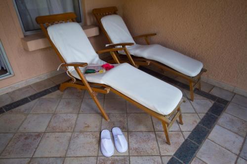 a group of three chairs sitting next to a wall at The Kairaba Beach Hotel in Kololi