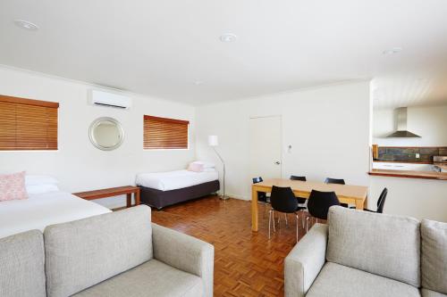 a hotel room with a bed and a table and chairs at Bay Beach Motel in Byron Bay