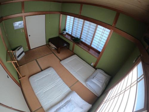 an overhead view of a room with two beds and two windows at Kumano Backpackers in Tanabe