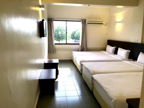 een hotelkamer met 2 bedden en een raam bij Hotel Sitiawan in Sitiawan