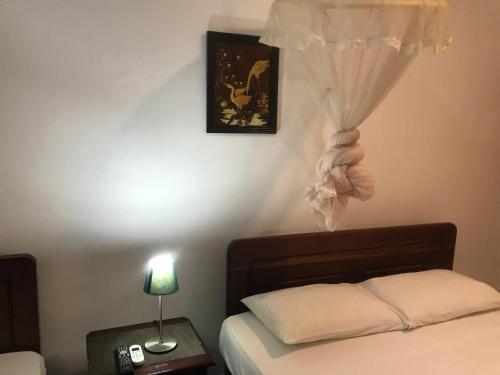 1 dormitorio con 1 cama con cortina en la pared en Dions Guest House, en Negombo
