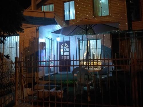 a house with a table and an umbrella at night at Alojamiento en Chillán in Chillán