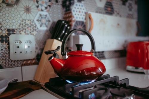 a red tea kettle sitting on top of a stove at Timeless Bloemfontein in Bloemfontein