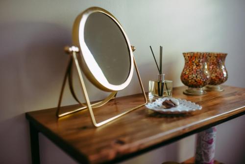 a mirror on top of a wooden table at Timeless Bloemfontein in Bloemfontein
