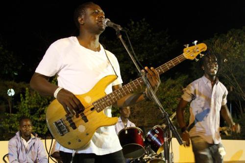 a man playing a guitar with a group of people at The Kairaba Beach Hotel in Kololi