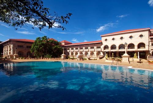 a large swimming pool in front of a building at Evershine Resort & Spa in Mahabaleshwar