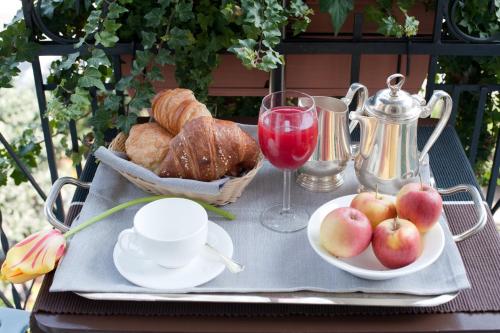 a tray with bread and apples and a glass of wine at Hotel Italia in Noli