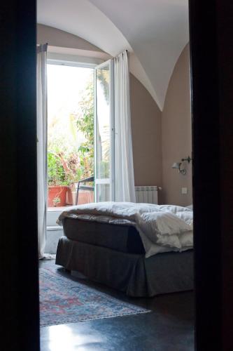 a bedroom with a bed and a large window at Hotel Italia in Noli