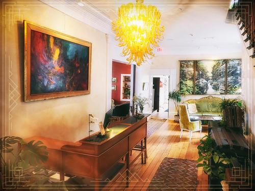 a living room filled with furniture and a painting on the wall at Argos Inn - Ithaca's Boutique Hotel in Ithaca