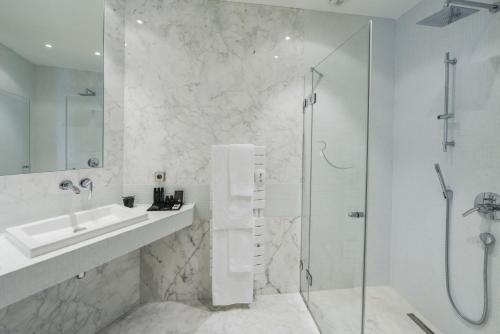 
a white bath tub sitting next to a white toilet at Hotel & Spa REGENT PETITE FRANCE in Strasbourg
