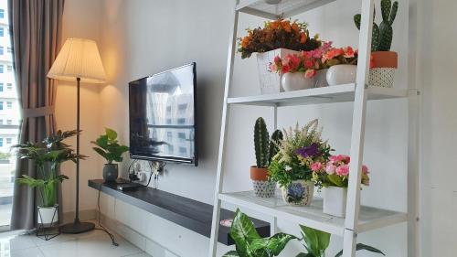 a room with shelves with potted plants and a tv at No.7 The Zebra @ Puchong Skypod Residence in Puchong