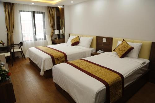 a hotel room with two beds and a table at Bảo Ngọc Diamond Hotel in Cao Bằng