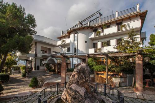 a building with a statue in front of it at Hotel Ristorante La Bilancia in Loreto Aprutino