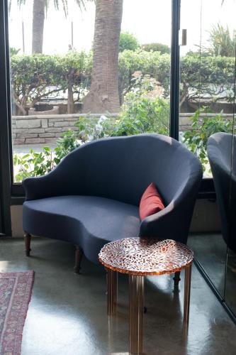 a blue couch with a red pillow and a table at Hotel Italia in Noli