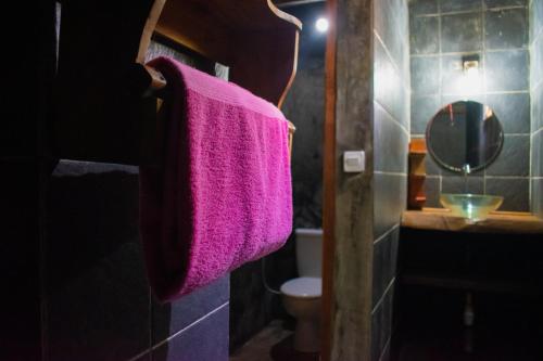 a bathroom with a pink towel hanging on a towel rack at Jati Village, Party Hostel and Bungalows in Gili Trawangan