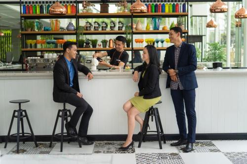 a group of people standing around a bar at d'primahotel Airport Jakarta 2 in Tangerang