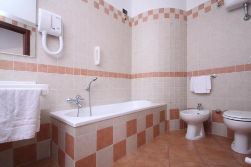 a bathroom with a tub and a toilet at Hotel Ristorante La Bilancia in Loreto Aprutino
