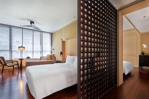 a hotel room with a large bed and a large window at The RuMa Hotel and Residences in Kuala Lumpur