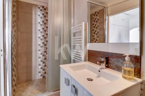 a bathroom with a sink and a mirror and a shower at F2 Centre - Gare in Nice