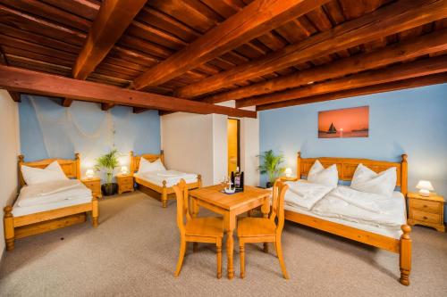 um quarto com duas camas e uma mesa e cadeiras em La Port em Znojmo