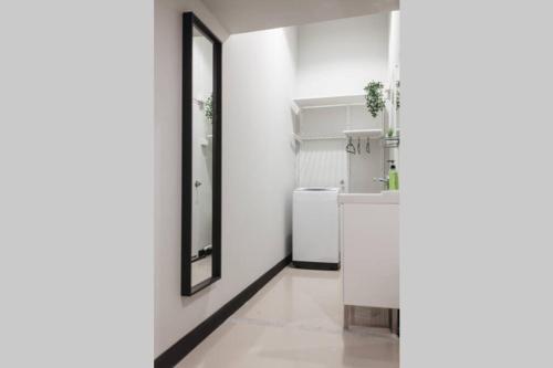 a white hallway with a mirror and a sink at S1 Large Duplex Silom 3 Beds, Full Kitchen WIFI in Bangkok