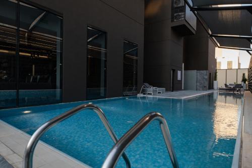a swimming pool in a building at Swiss-Belboutique Bneid Al Gar Kuwait in Kuwait