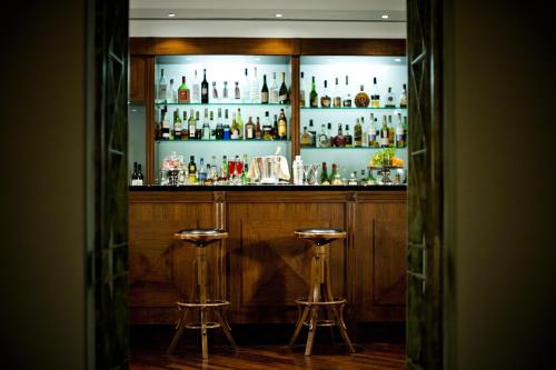 a bar with two stools in front of a shelf of alcohol at Hotel Ponte Sisto in Rome