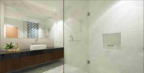 a bathroom with a sink and a glass shower at Summit Hotel Naga in Naga