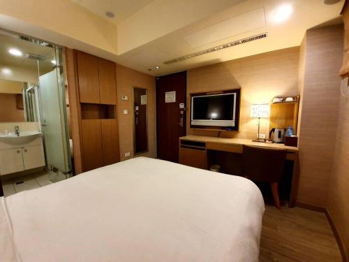 A bed or beds in a room at Guide Hotel Taipei NTU