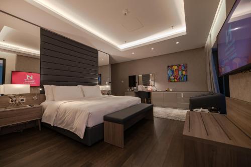 a bedroom with a large bed and a living room at Swiss-Belboutique Bneid Al Gar Kuwait in Kuwait