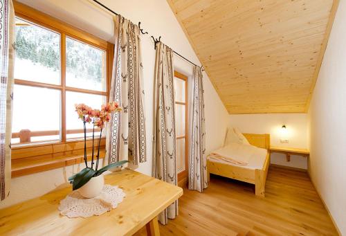 HüttschlagにあるAlmliesl HUET-484のテーブルとベッド、窓が備わる客室です。