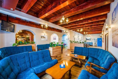 a living room with blue couches and wooden ceilings at La Port in Znojmo
