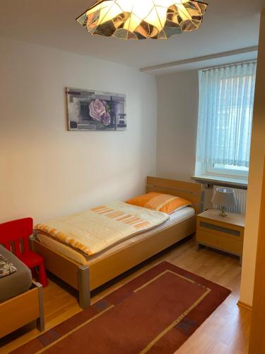 um pequeno quarto com uma cama e uma janela em City Apartment in Nürnberg em Nurembergue