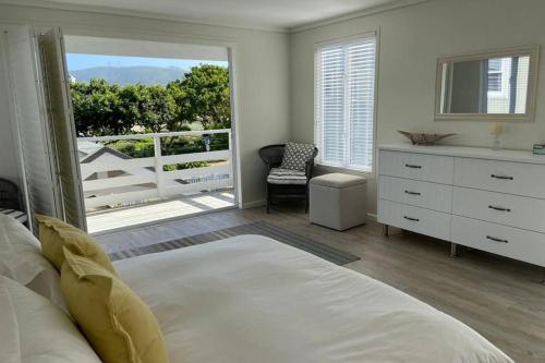 a bedroom with a bed and a view of a balcony at Summit Song - Thesen Island in Knysna