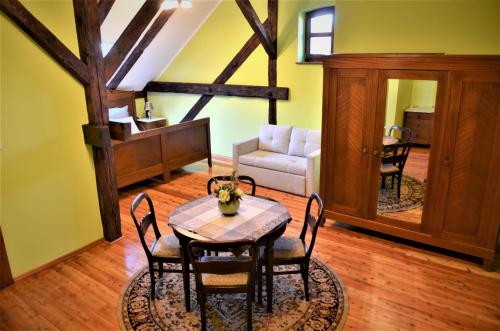 a dining room with a table and a couch at Folwark Pszczew in Pszczew
