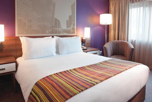 a hotel room with a large bed and a desk at Garden Court Sandton City in Johannesburg