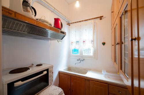 a small kitchen with a stove and a window at Giameiko Traditional House Kalymnos in Kalymnos