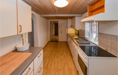 a kitchen with white cabinets and a wooden ceiling at 3 Bedroom Cozy Home In Sydals in Lillekobbel