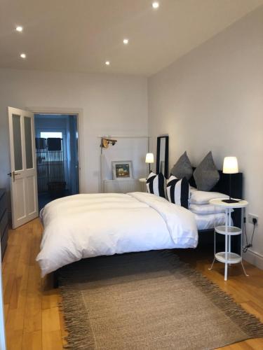 a bedroom with two beds with white sheets and black pillows at The Harbour Studio in Portrush