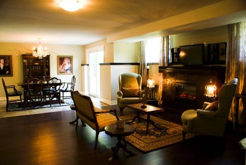 a living room with a fireplace and a dining room at Sapience Retreat & Apothecary in Niagara on the Lake