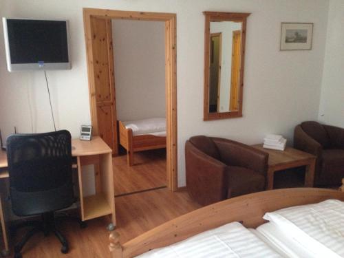 a bedroom with a bed and a desk and a chair at Hotel zur Post Kleve in Kleve