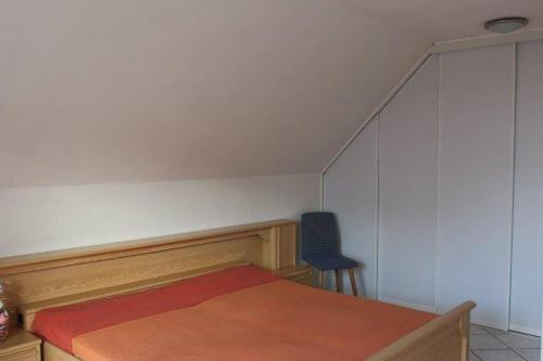 a bedroom with a bed and a blue chair at Ferienhaus Mey in Bad Salzungen