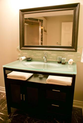 a bathroom with a sink and a mirror at Sapience Retreat & Apothecary in Niagara-on-the-Lake