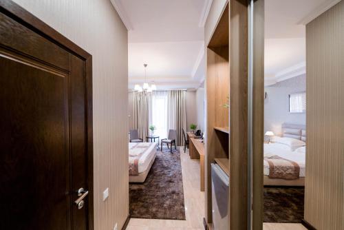 a hotel room with two beds and a desk at Oasis Residence in Bishkek