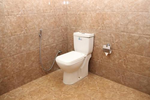 a bathroom with a toilet with a hose connected to it at Thal Sewana in Sigiriya