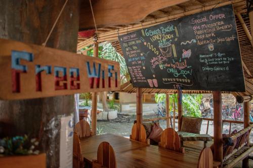 a restaurant with a table with a chalkboard on the wall at Jati Village, Party Hostel and Bungalows in Gili Trawangan