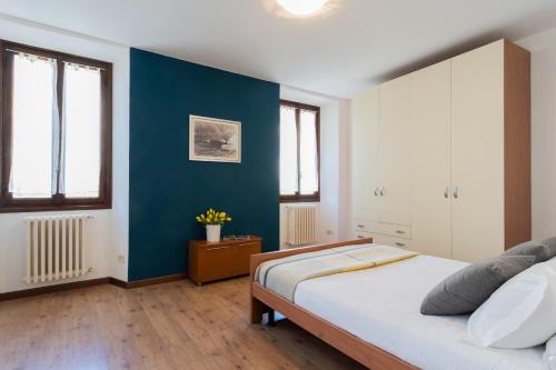a bedroom with a bed and a blue wall at Family Lake Apartment by Rent All Como in Mezzegra