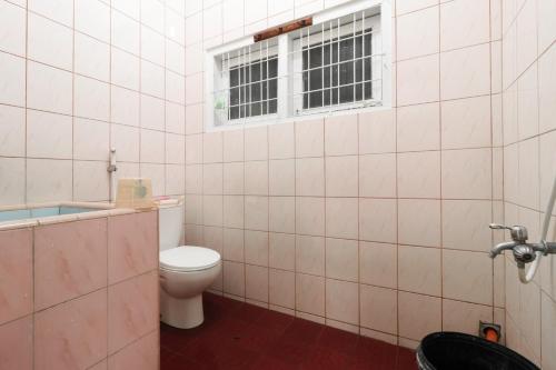 bagno con servizi igienici e finestra. di Waroeng Transit & Depary Homestay a Binjai